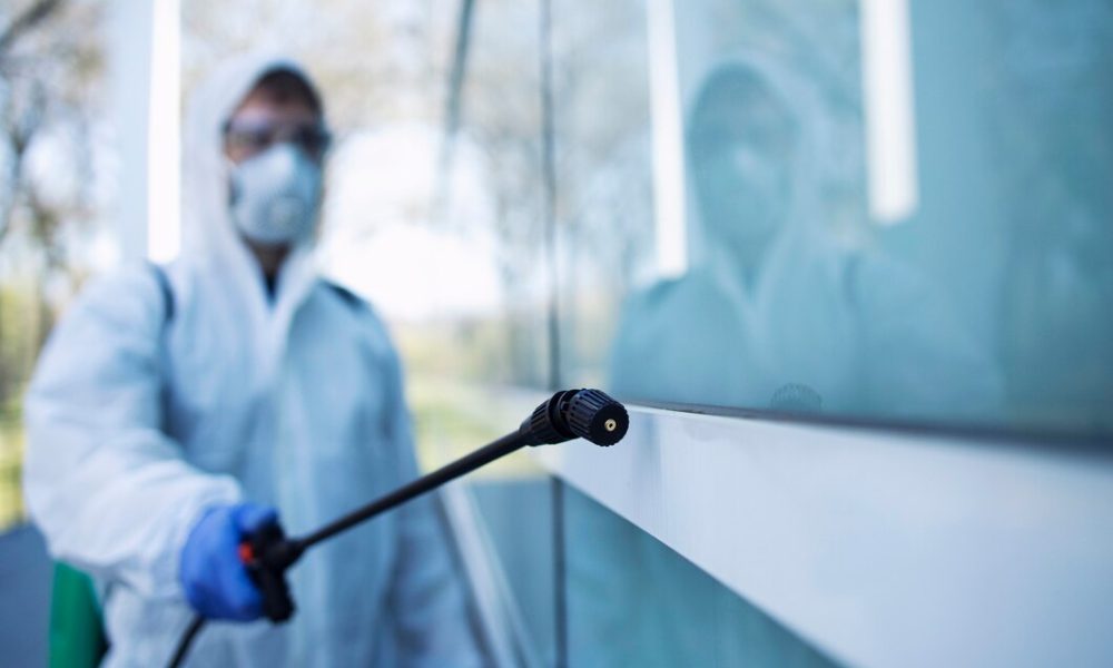 colpo-di-persona-di-sesso-maschile-in-tuta-di-protezione-chimica-bianca-che-esegue-la-disinfezione-delle-aree-pubbliche-per-fermare-la-diffusione-del-virus-corona-altamente-contagioso_342744-914